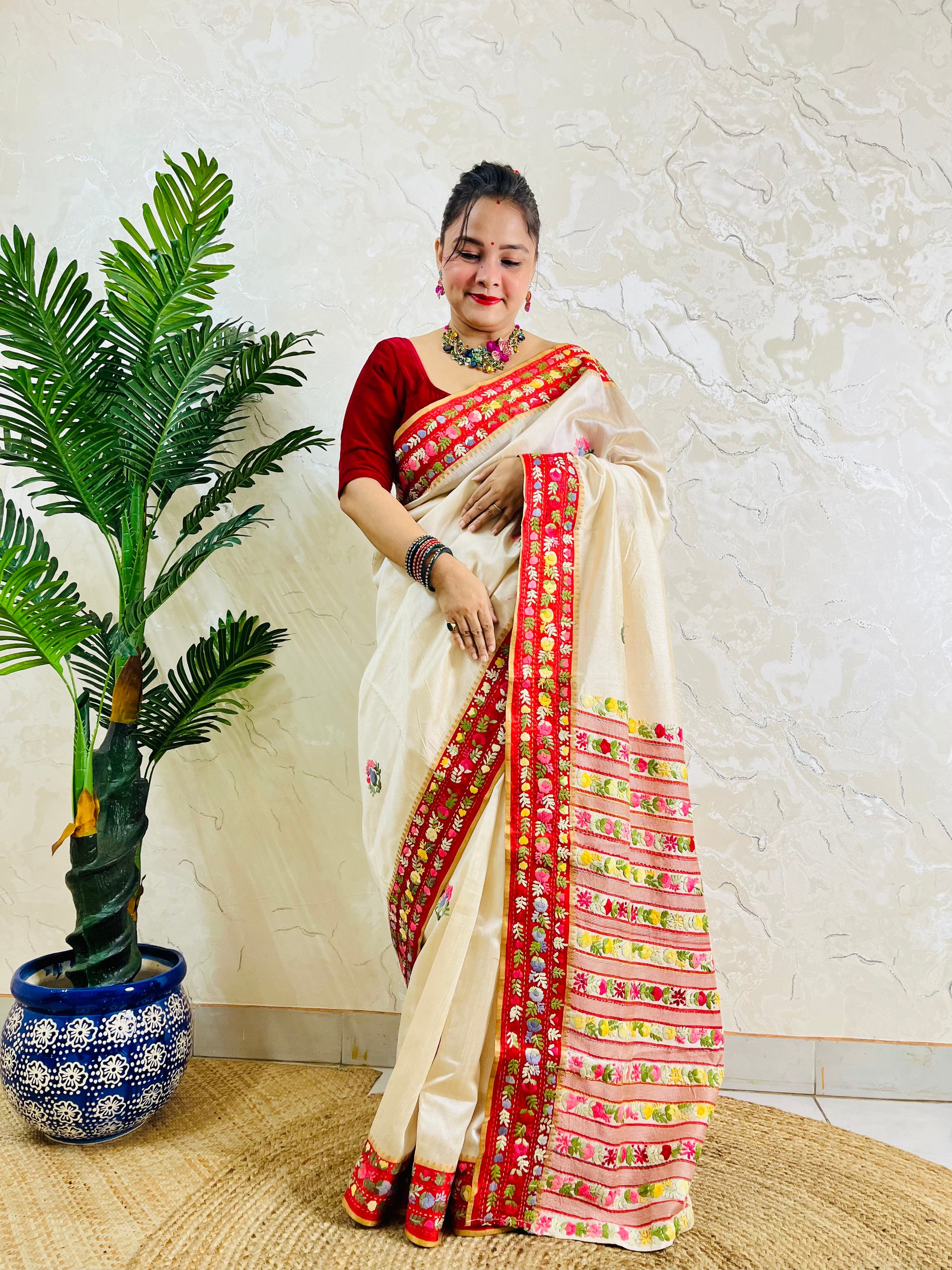 Front standing view of Parsi Gara handwoven Semi Muga Silk saree with red velvet border and multicolour floral embroidery — heirloom saree by Desi Aadat