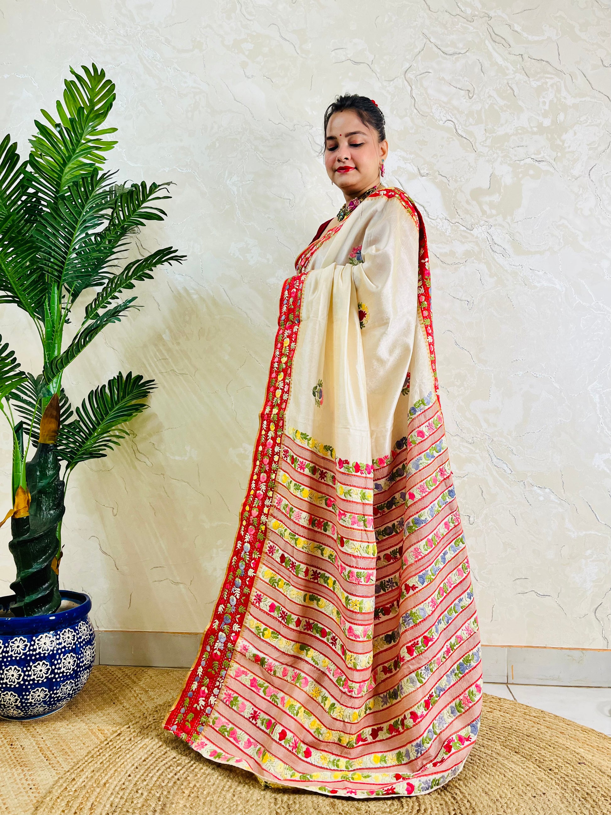 Front standing view of Parsi Gara handwoven Semi Muga Silk saree with red velvet border and multicolour floral embroidery — heirloom saree by Desi Aadat