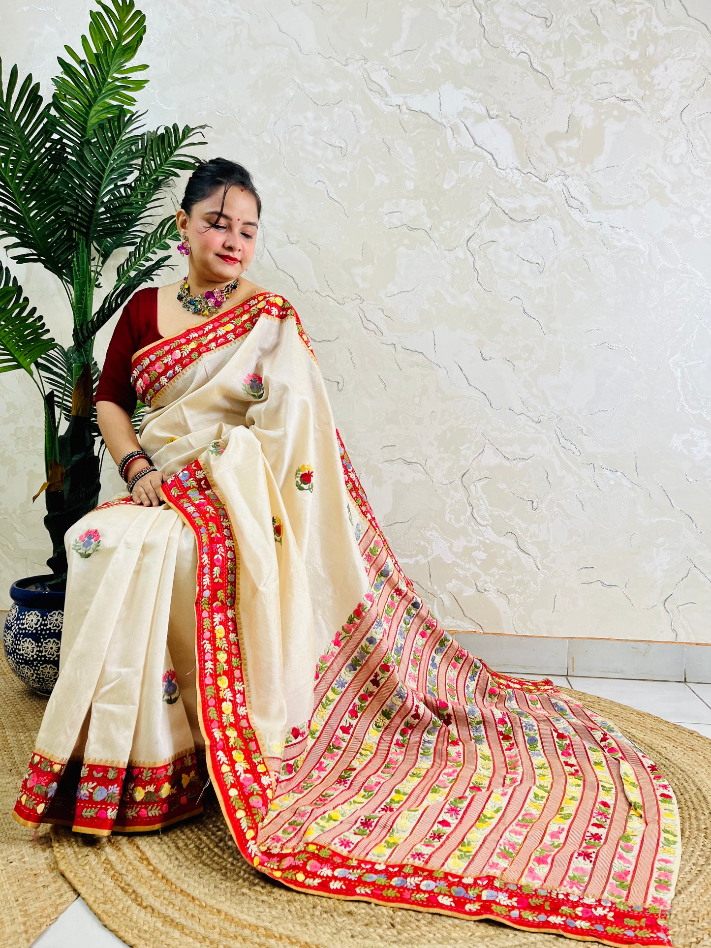 Front standing view of Parsi Gara handwoven Semi Muga Silk saree with red velvet border and multicolour floral embroidery — heirloom saree by Desi Aadat