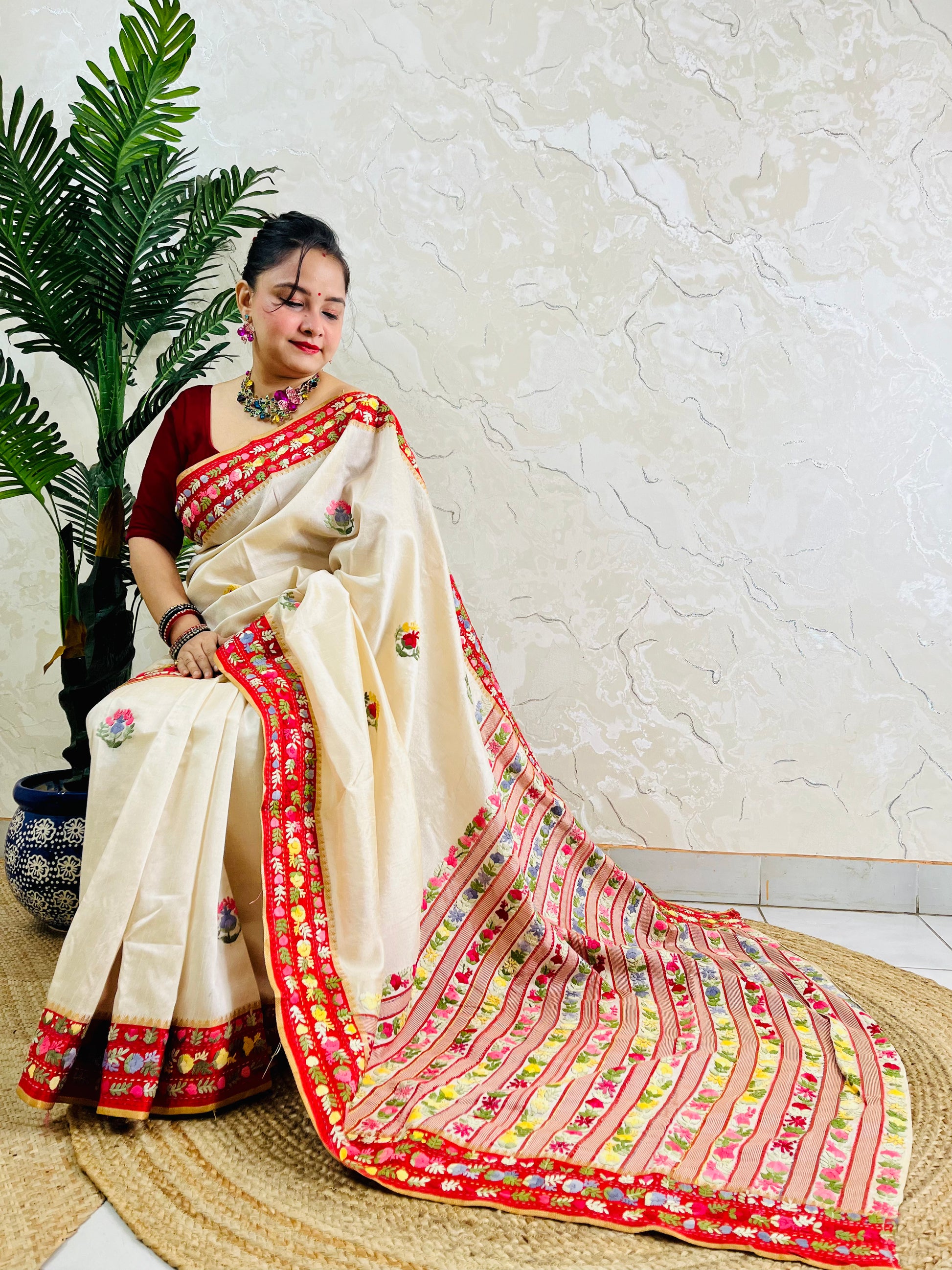 Front standing view of Parsi Gara handwoven Semi Muga Silk saree with red velvet border and multicolour floral embroidery — heirloom saree by Desi Aadat