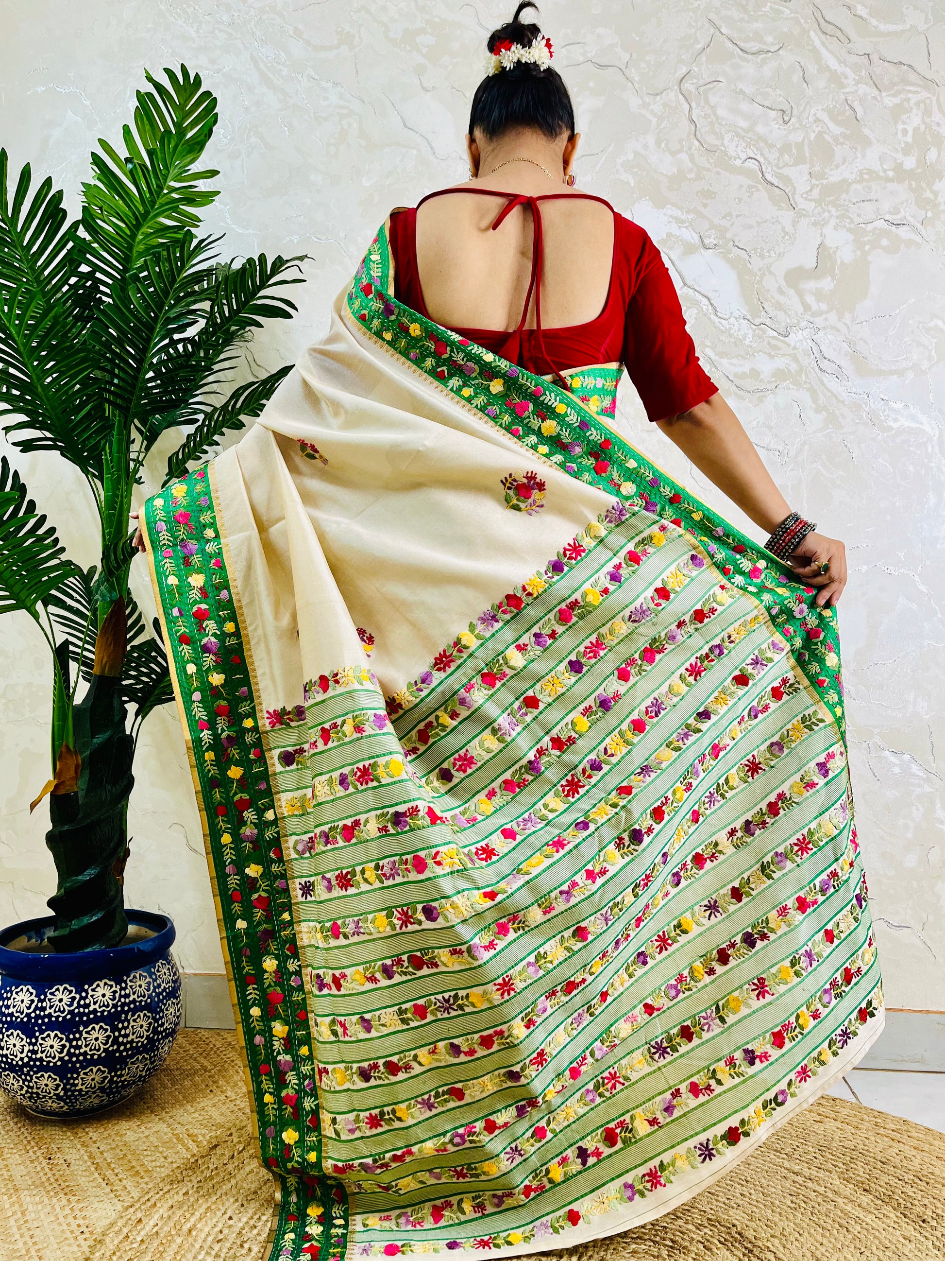 Back view of Parsi Gara handwoven Semi Muga Silk saree with emerald green velvet Kardana border and lush horizontal floral garden stripe pallu in motion — Desi Aadat