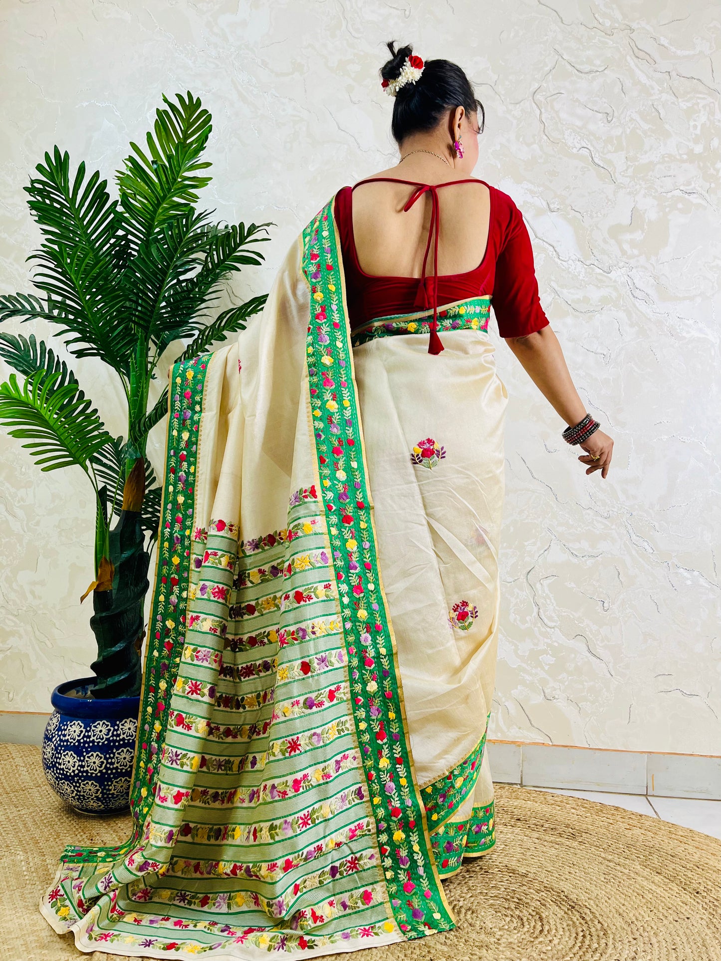 Back view of Parsi Gara handwoven Semi Muga Silk saree with emerald green velvet Kardana border and lush horizontal floral garden stripe pallu in motion — Desi Aadat