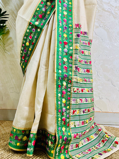 Bottom view of emerald green velvet Parsi Gara embroidered border with Kardana work and multicolour floral hand embroidery on ivory Semi Muga Silk saree — Desi Aadat