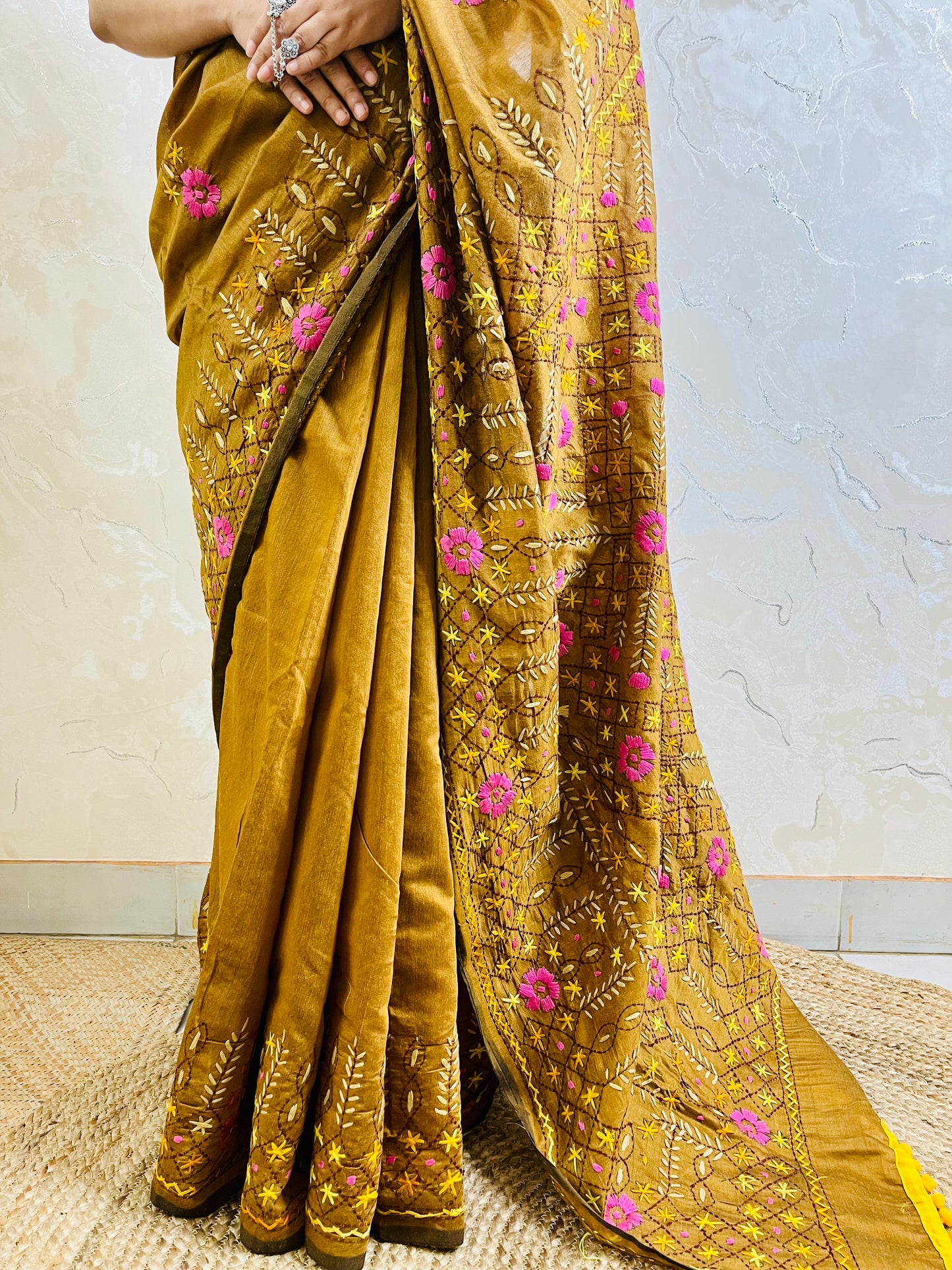 Close-up of all-over Jali trellis grid with pink daisy florals, yellow star stitches, and cream leaf Parsi Gara hand embroidery on golden brown Chanderi silk cotton saree — Desi Aadat