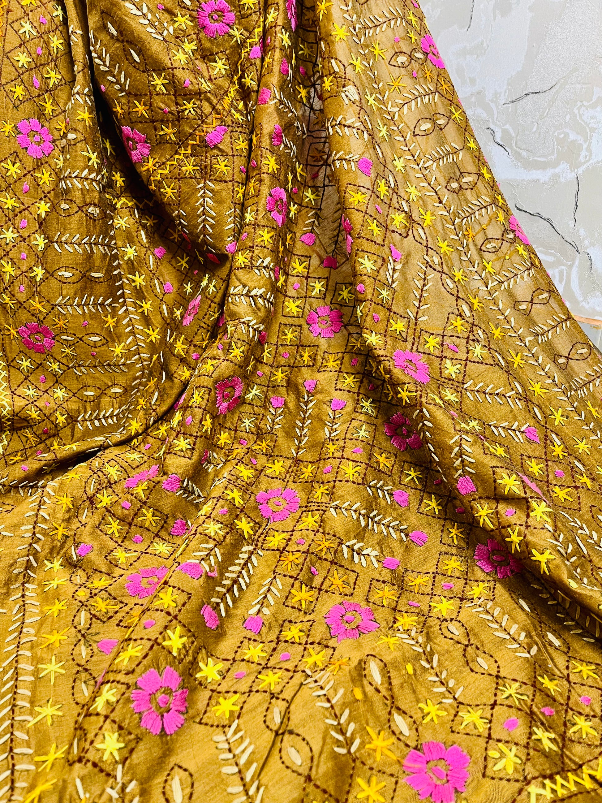 Close-up of all-over Jali trellis grid with pink daisy florals, yellow star stitches, and cream leaf Parsi Gara hand embroidery on golden brown Chanderi silk cotton saree — Desi Aadat