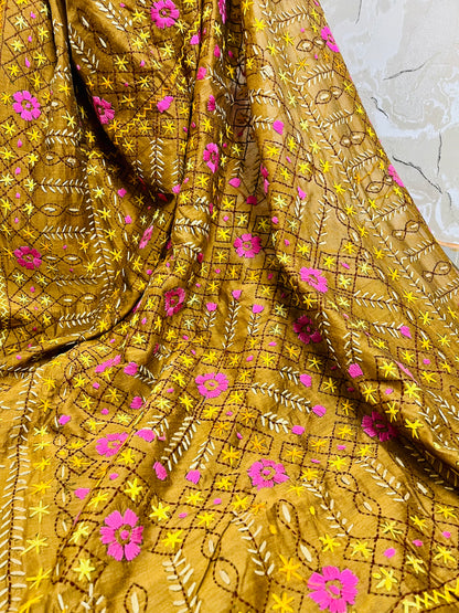 Close-up of all-over Jali trellis grid with pink daisy florals, yellow star stitches, and cream leaf Parsi Gara hand embroidery on golden brown Chanderi silk cotton saree — Desi Aadat