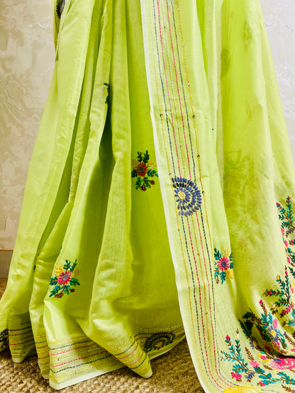 Close-up of handstitched Parsi Gara multicolour floral, butti medallion, and sequin running stitch border on pastel lime Chanderi silk cotton saree — Desi Aadat