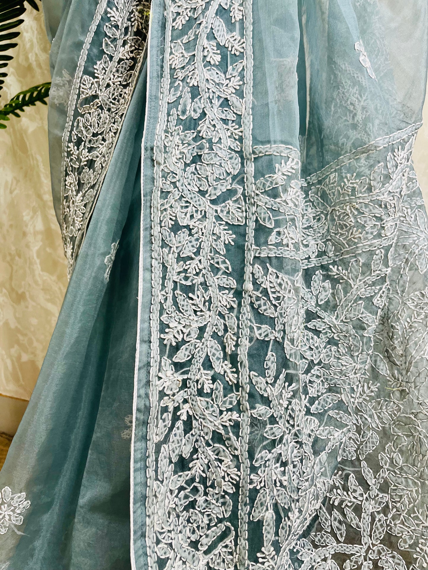 Close-up of structured white Lucknowi Chikankari jaal, vine, and shadow stitch hand embroidery on pastel dusty blue pure organza silk saree — Desi Aadat