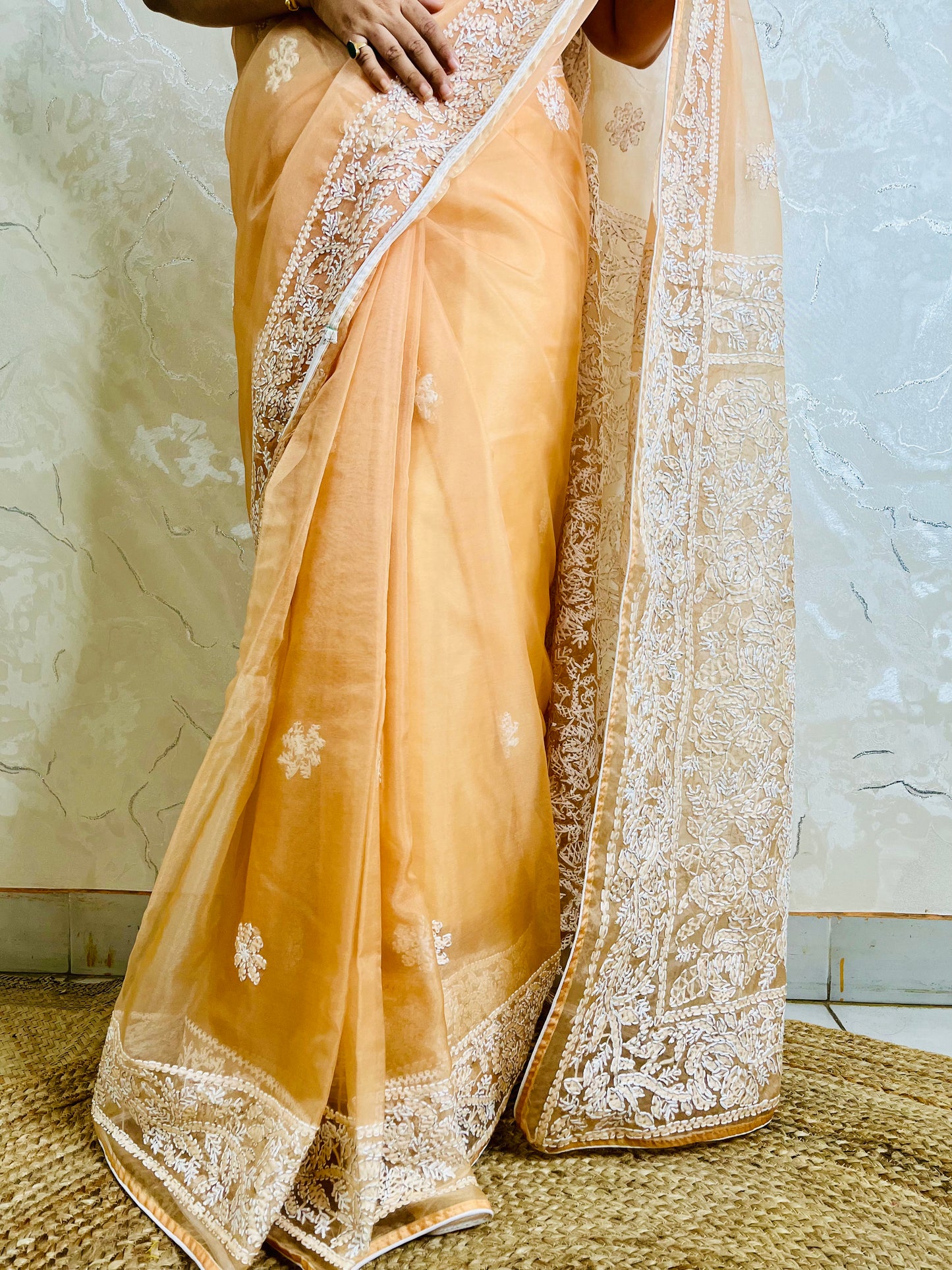 Close-up of dense white Lucknowi Chikankari jaal and leaf embroidery on pastel peach orange pure organza silk saree — Desi Aadat