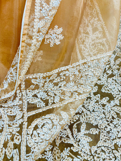 Close-up of dense white Lucknowi Chikankari jaal and leaf embroidery on pastel peach orange pure organza silk saree — Desi Aadat