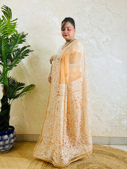Pastel peach orange Chikankari handstitched organza silk saree with full white jaal and floral embroidery — side standing view, Desi Aadat