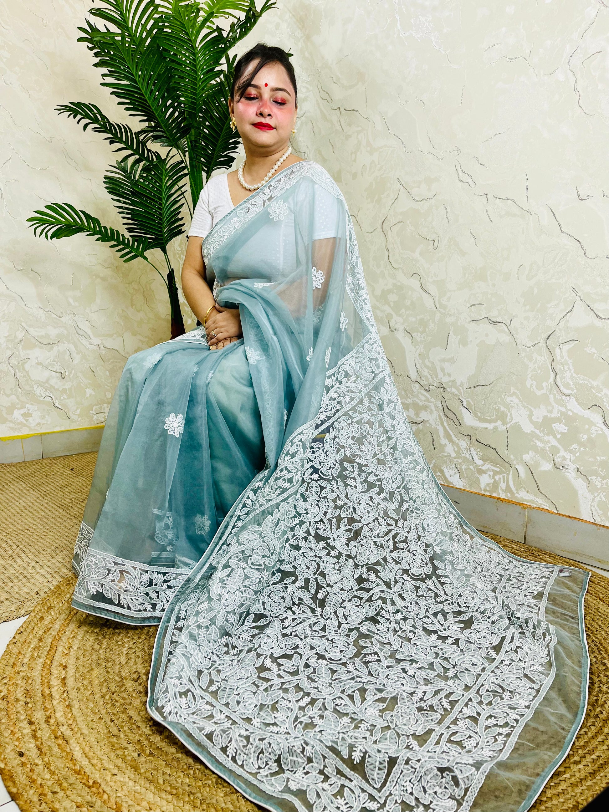 Handmade Lucknowi Chikankari pastel powder blue pure organza silk saree with dense white jaal and floral embroidery — sitting drape view, Desi Aadat