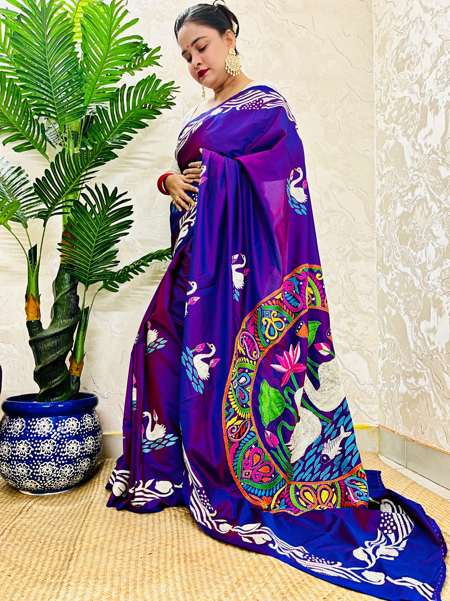 Close-up of swarn golden motif Kantha embroidery on rich purple handwoven fabric