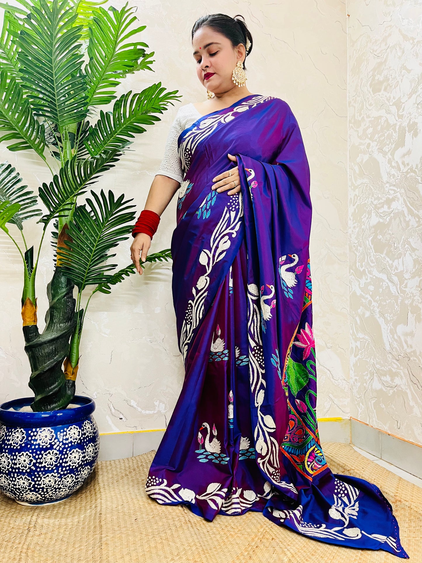 Close-up of swarn golden motif Kantha embroidery on rich purple handwoven fabric