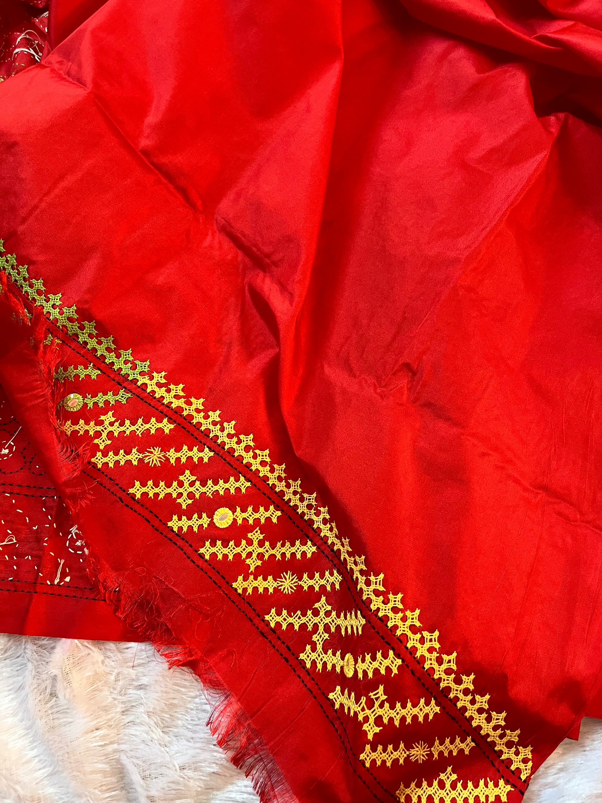 Matching red blouse piece with coordinating green yellow white Gujarati stitch details