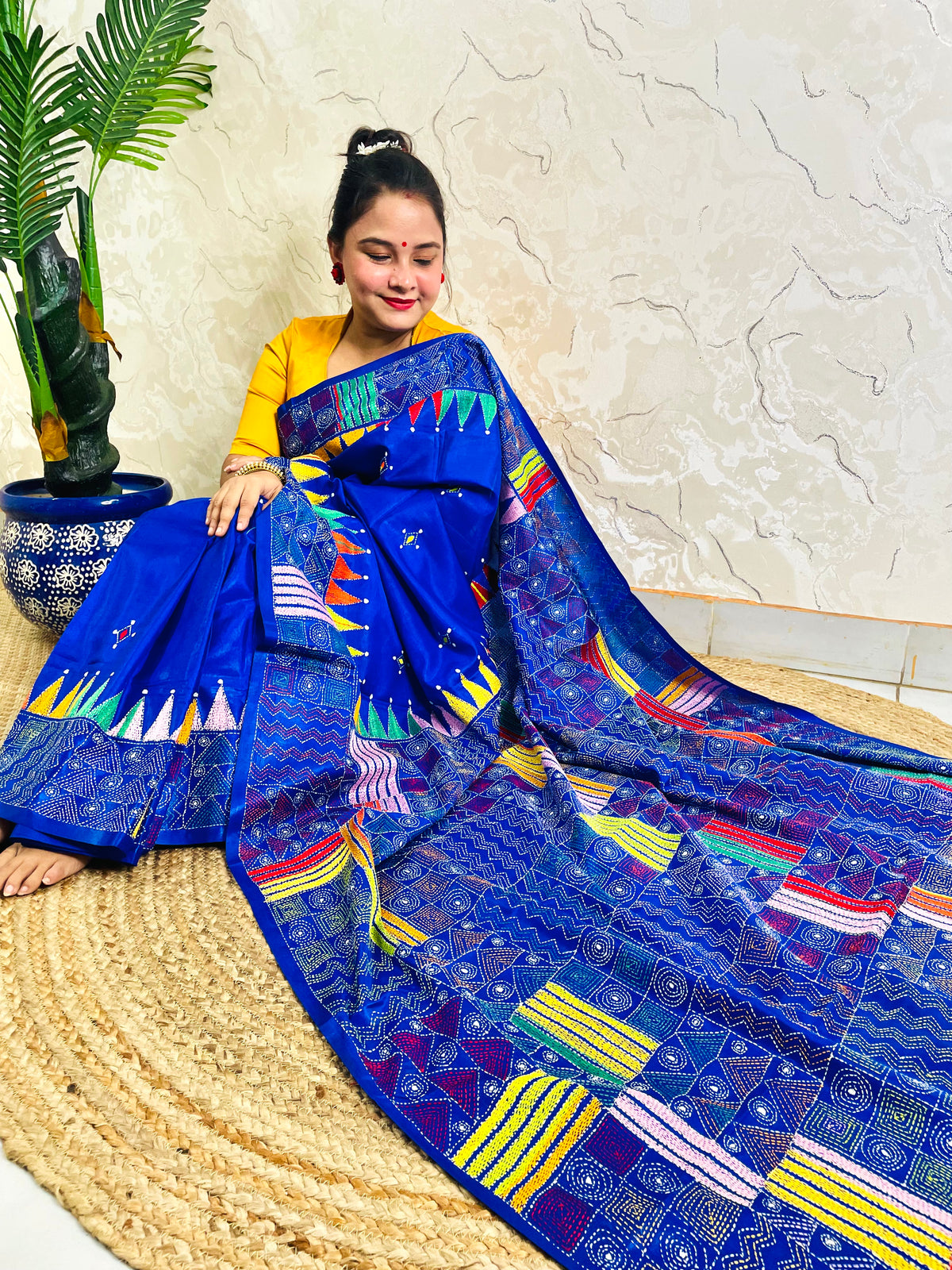 Sitting view of royal blue Kantha saree showing pennant flag pallu detail