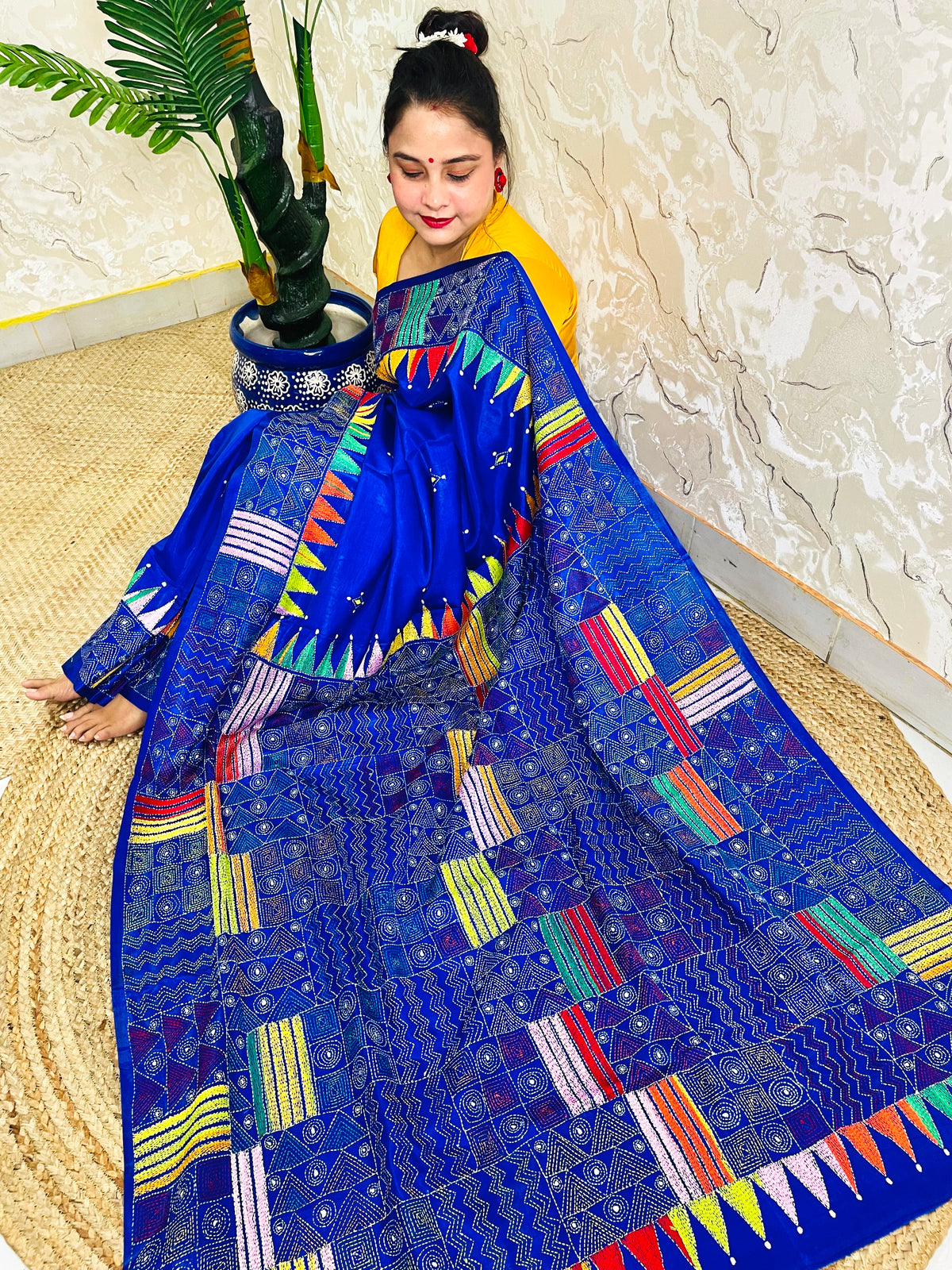 Sitting view of royal blue Kantha saree showing pennant flag pallu detail