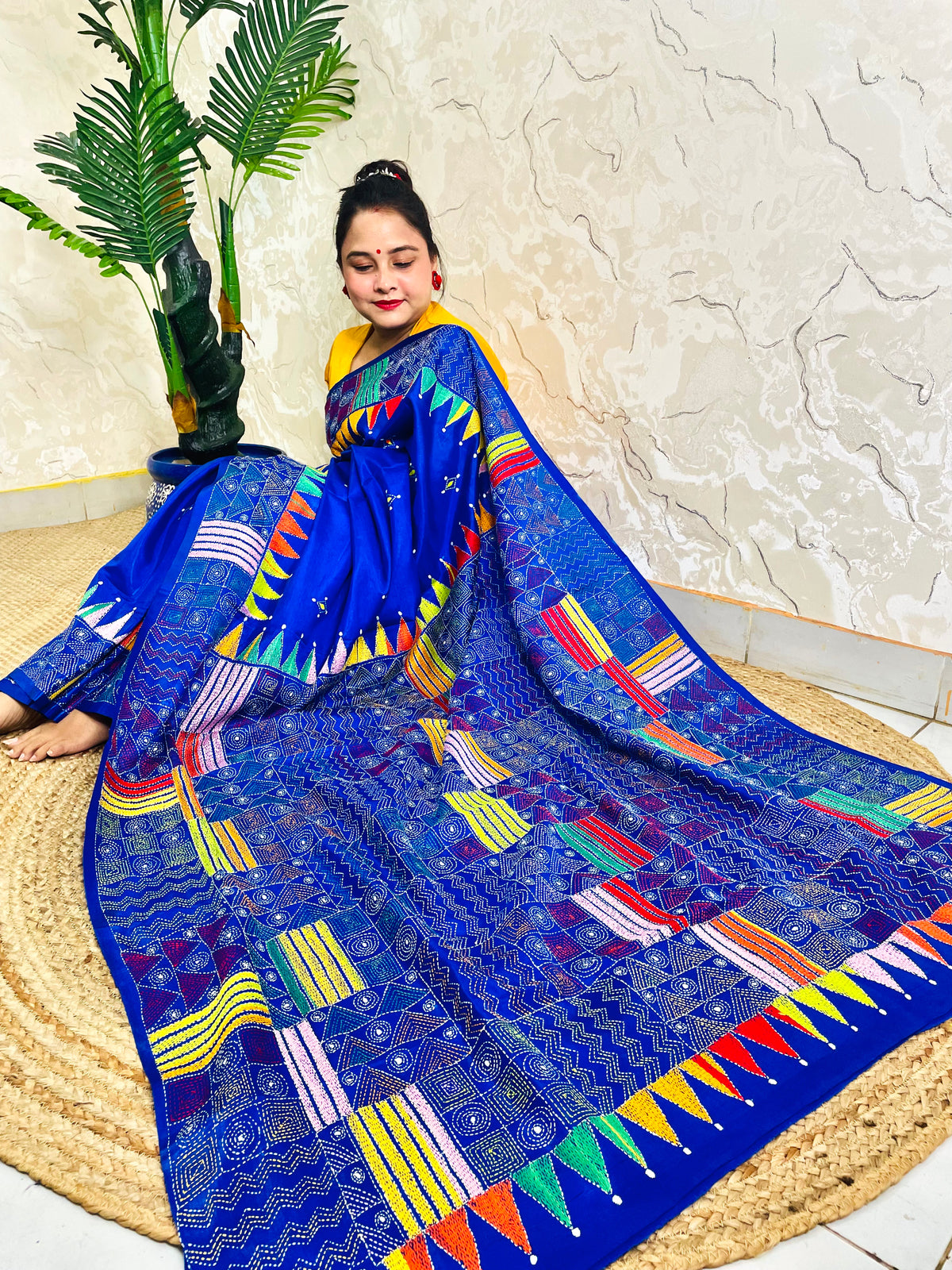 Sitting view of royal blue Kantha saree showing pennant flag pallu detail