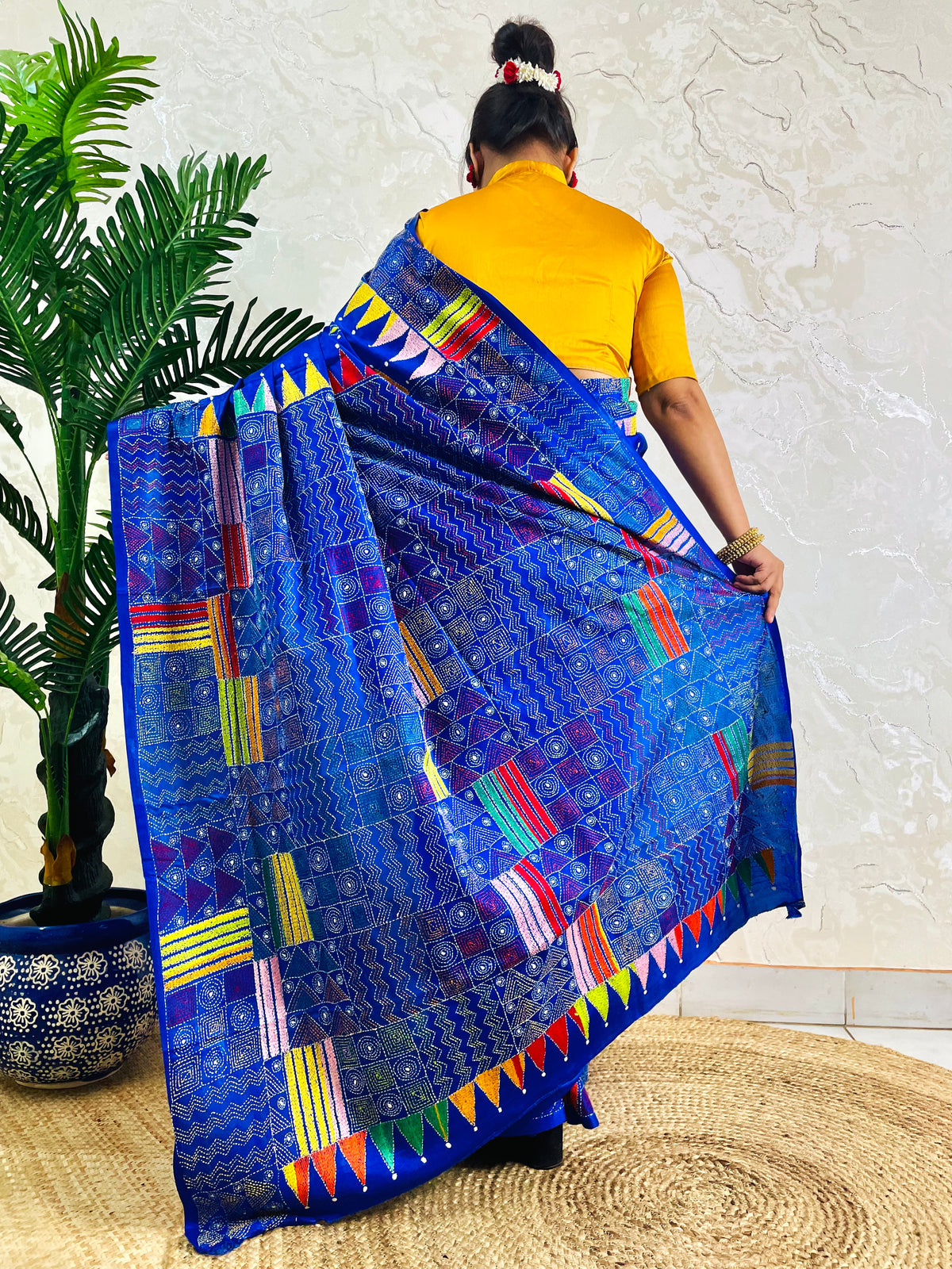 Back standing view of royal blue Kantha saree with pennant border pallu