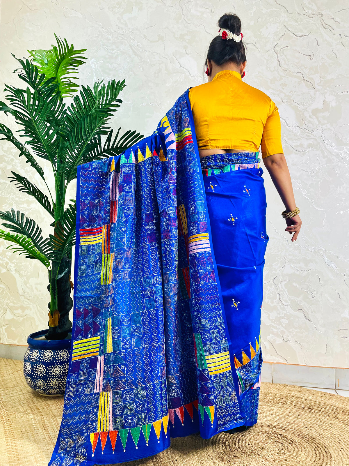 Back standing view of royal blue Kantha saree with pennant border pallu