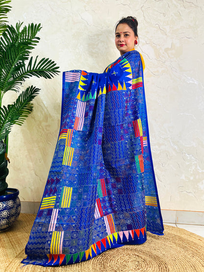Side standing view of royal blue Kantha stitch saree with colourful pennant border