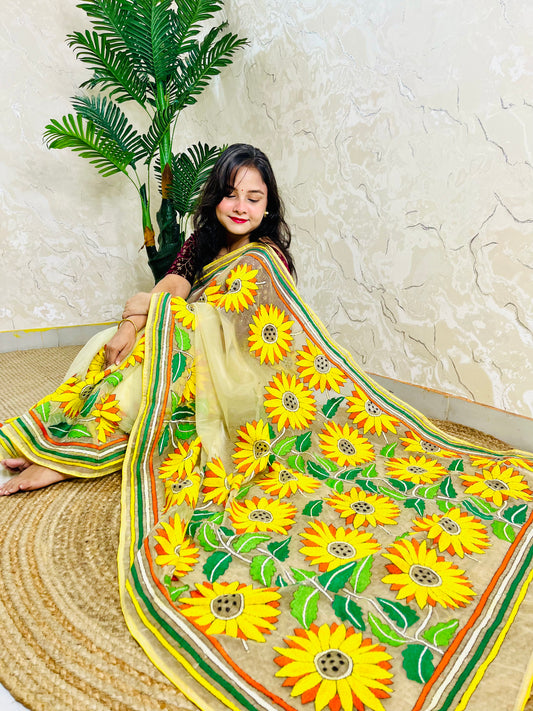 Pastel yellow organza saree with handmade sunflower Kantha stitch embroidery displayed in sitting pallu view — Desi Aadat