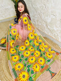 Handmade sunflower Kantha stitch blush pink organza saree with large golden yellow sunflower blooms and multicolour stripe border — angled sitting drape view, Desi Aadat