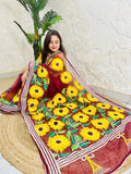 Woman wearing wine red hand-embroidered Kantha stitch sunflower saree, side seated pose