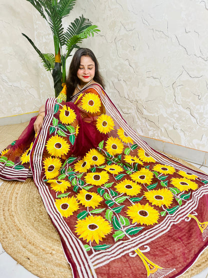 Woman wearing wine red hand-embroidered Kantha stitch sunflower saree, side seated pose