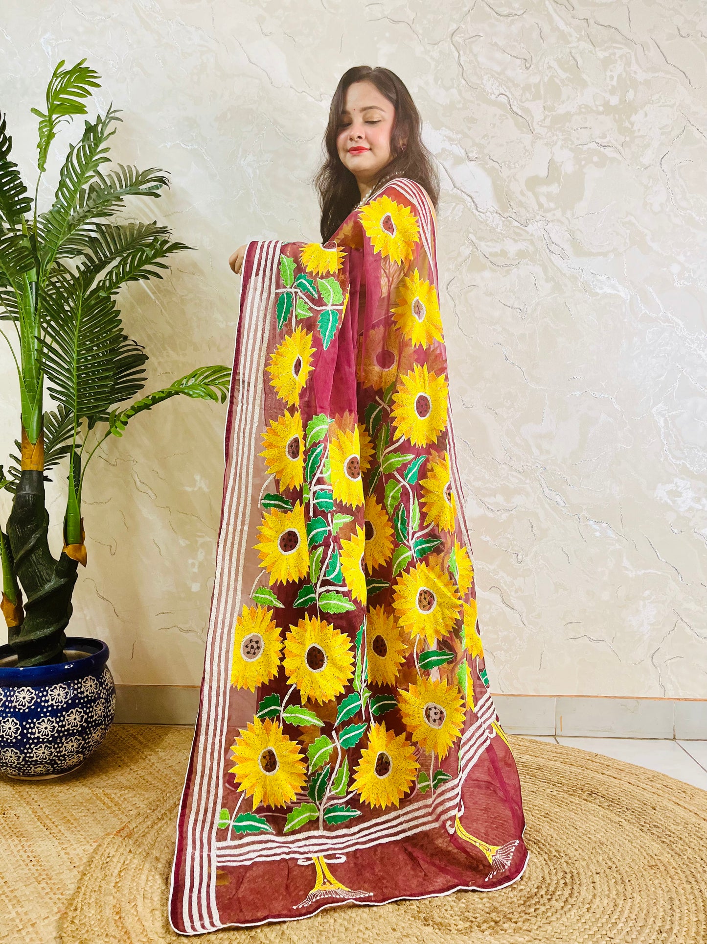 Wine red Kantha stitch organza saree with sunflower embroidery, front standing view