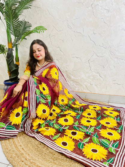 Woman wearing wine red hand-embroidered Kantha stitch sunflower saree, side seated pose