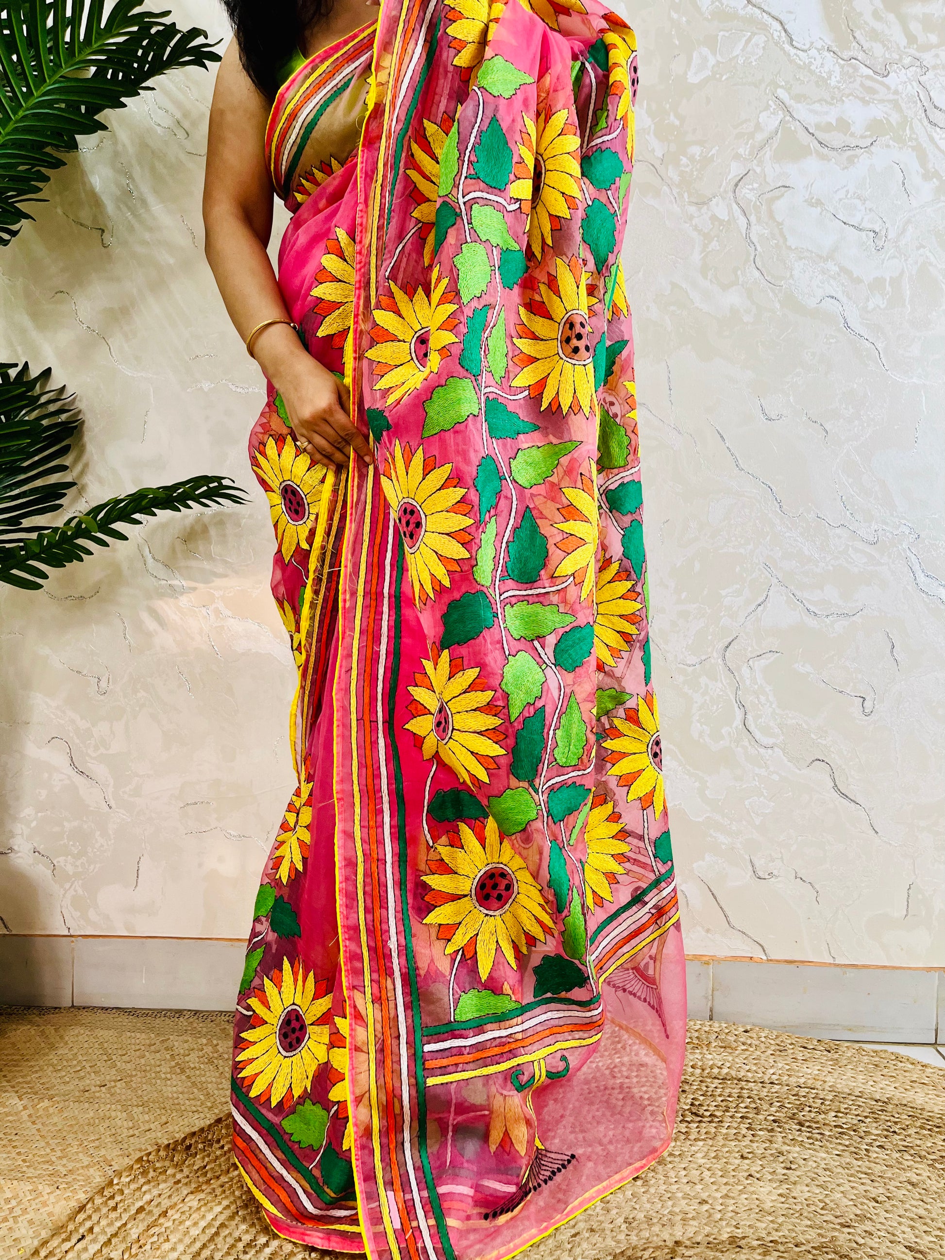 Close-up of hand-stitched Sunflower Kantha embroidery in mustard and green thread on baby pink organza saree – Desi Aadat