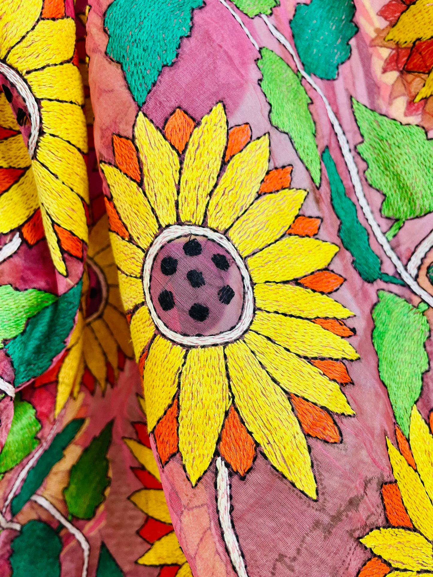 Close-up of hand-stitched Sunflower Kantha embroidery in mustard and green thread on baby pink organza saree – Desi Aadat