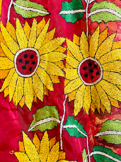 Close-up of hand-embroidered sunflower Kantha stitch on crimson red organza
