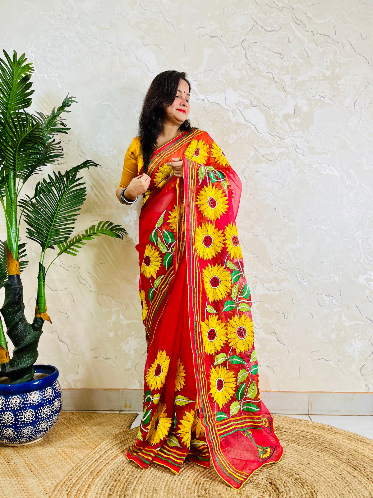 Front standing view of crimson red organza saree with sunflower embroidery