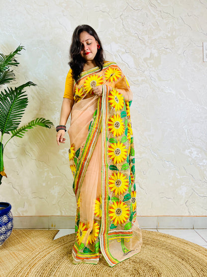 Woman standing in light peach sunflower Kantha stitch saree, side view