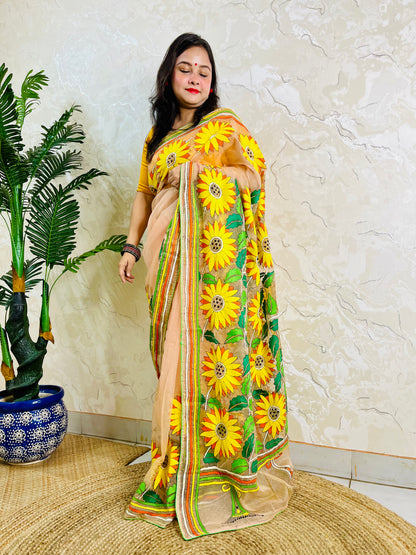 Woman standing in light peach sunflower Kantha stitch saree, side view