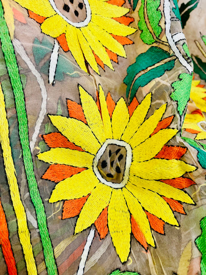 Close-up of bicolor sunflower Kantha stitch embroidery on light peach organza
