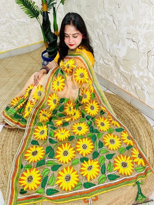 Woman seated in light peach sunflower Kantha stitch saree, top view