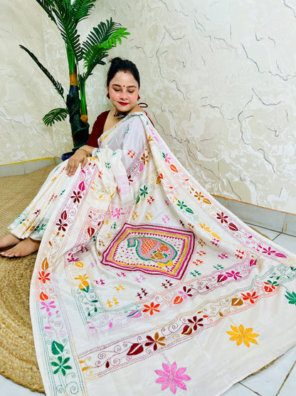 Woman seated in white Kantha stitch saree with paisley pallu spread out