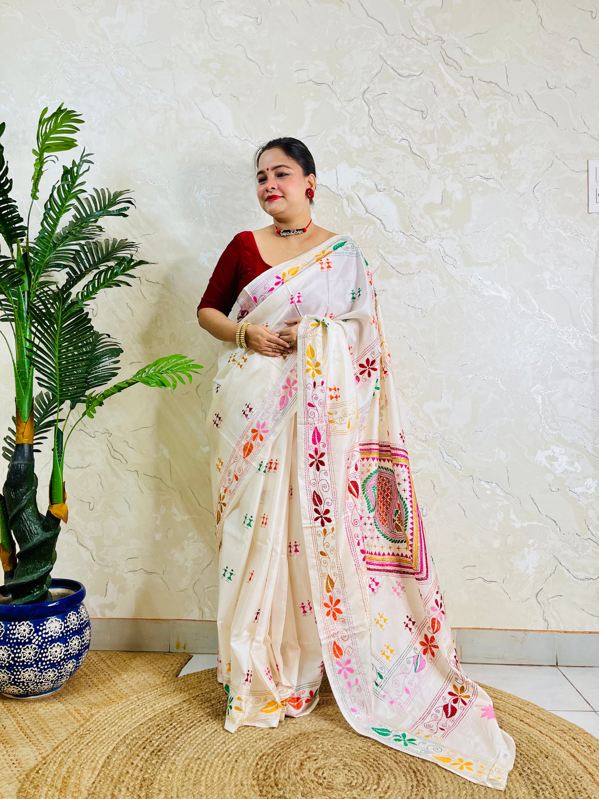 White handwoven saree draped standing pose with Kantha embroidery pallu detail