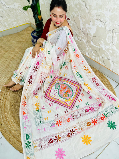 Woman seated in white Kantha stitch saree with paisley pallu spread out