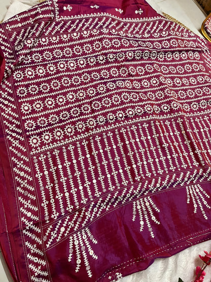 Close-up of mathematical geometric patterns and structured mirror work on wine red Bangalore silk fabric