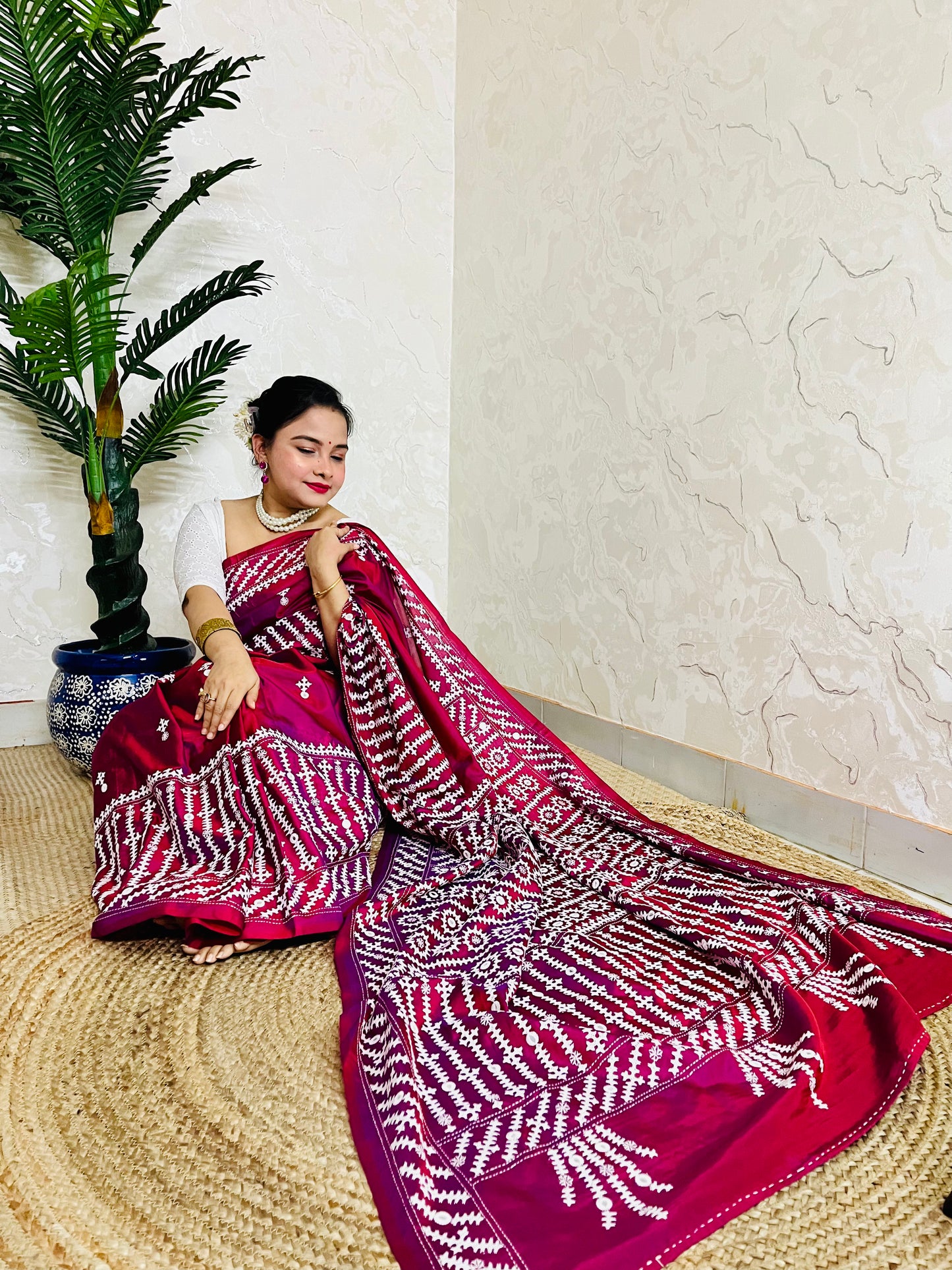 A women wearing Wine red Gujarati Stitch Saree with precise Kutch geometric hand embroidery and mirror work by Desi Aadat