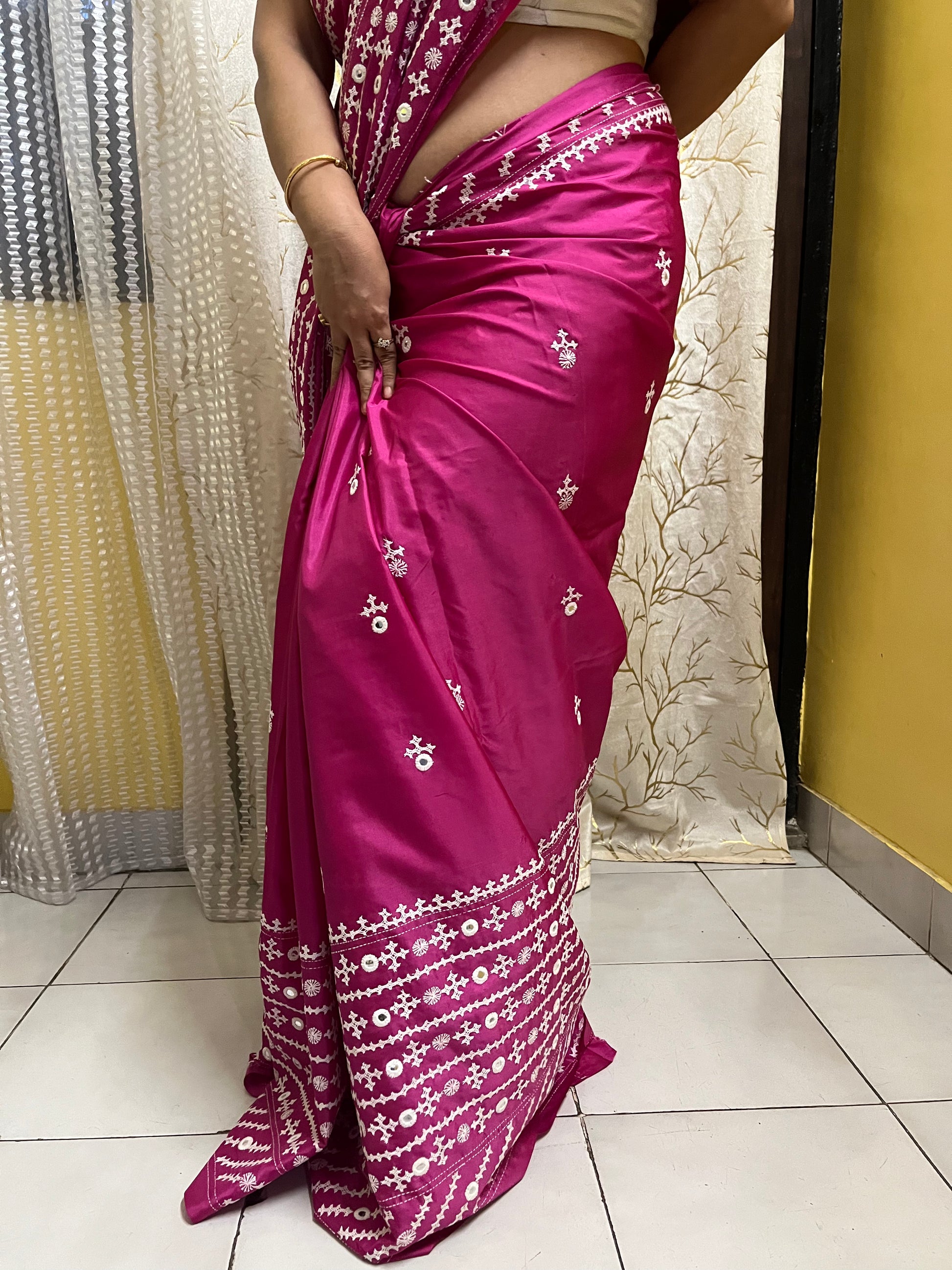 A model wearing a Burgundy Gujarati Stitch Saree with authentic Kutch hand embroidery and royal mirror work showcasing lower part of saree by Desi Aadat