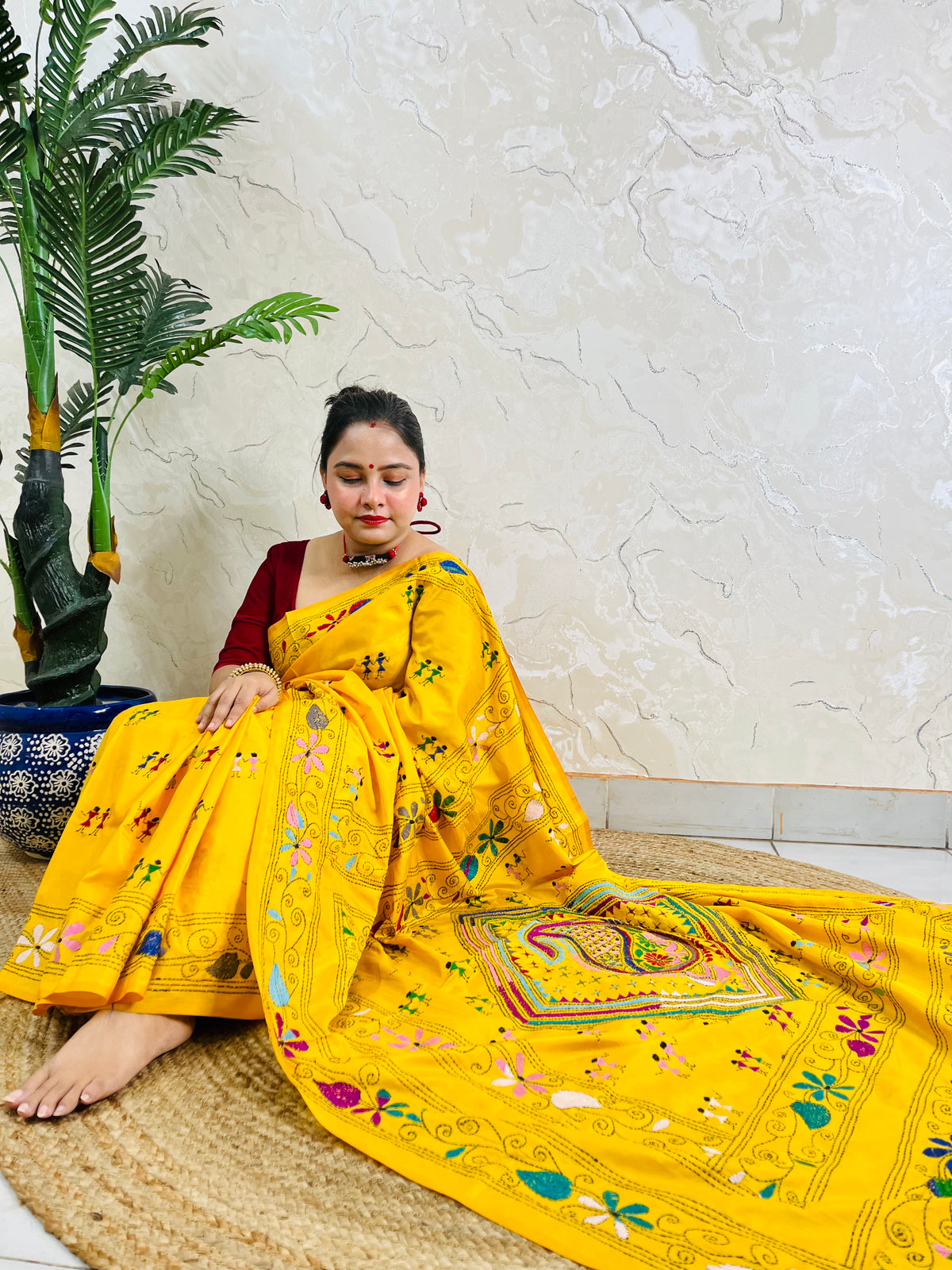 Yellow Kantha stitch saree with paisley pallu, full drape seated pose