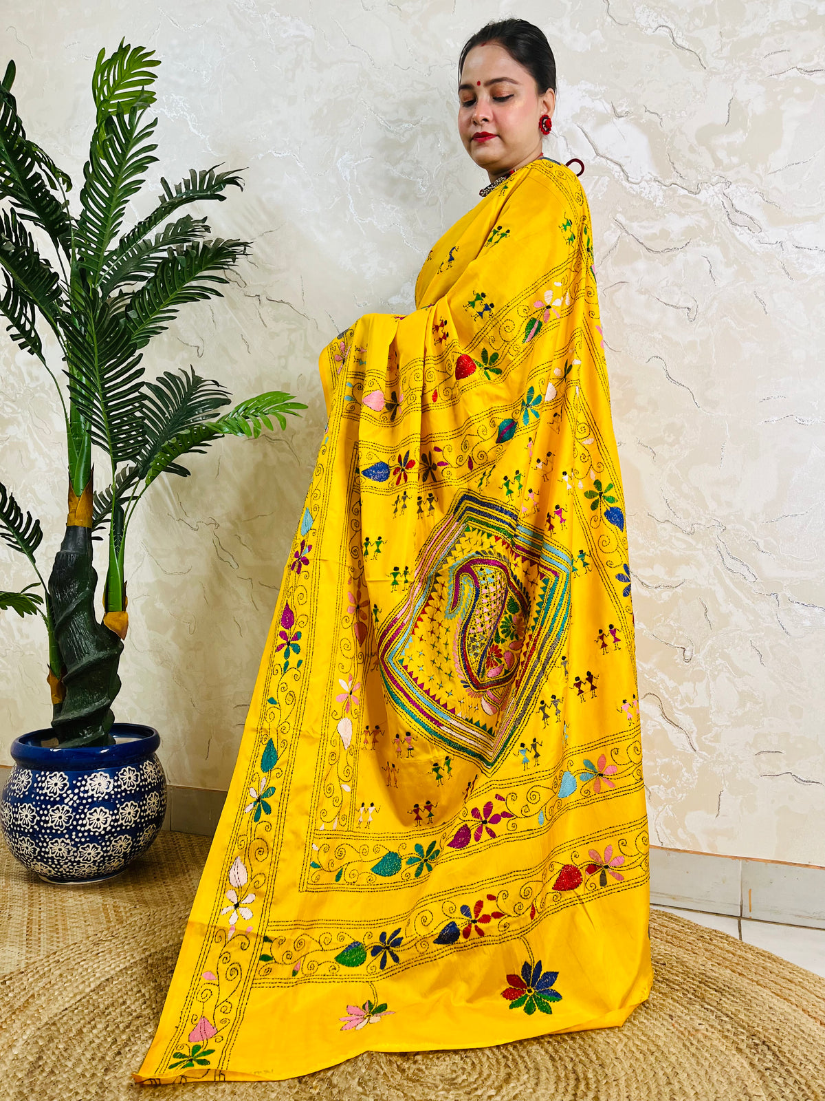 Yellow handwoven saree back drape showing floral border embroidery detail