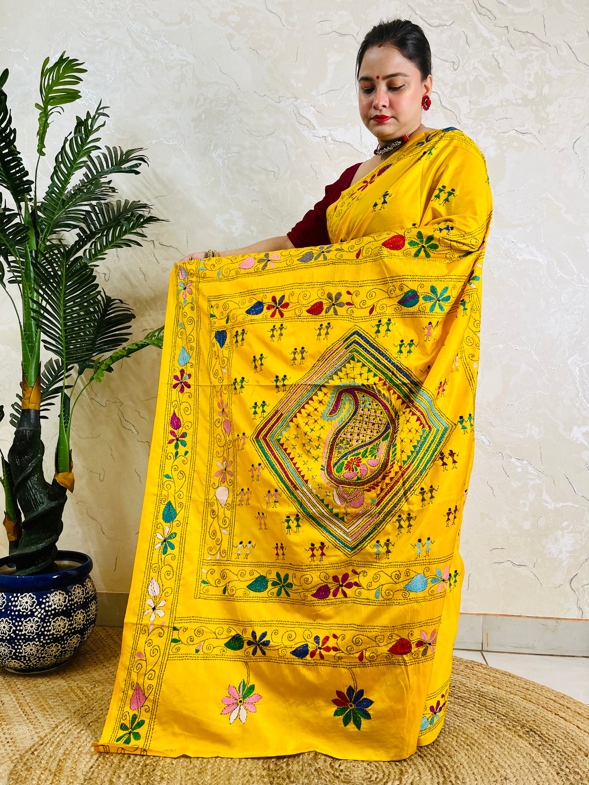 Yellow handwoven saree back drape showing floral border embroidery detail